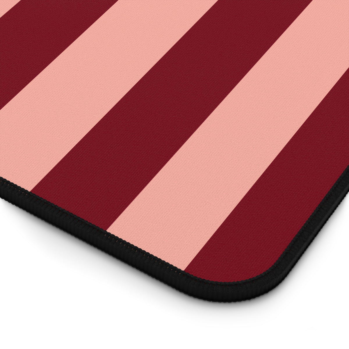 Burgundy blush striped desk mat under a keyboard and mouse