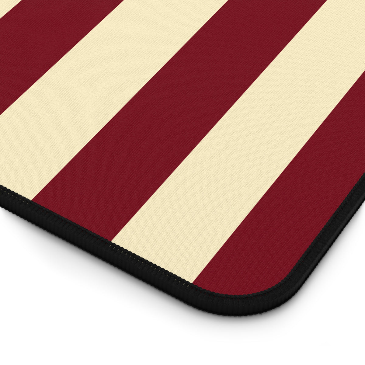 Burgundy butter yellow striped desk mat under a keyboard and mouse