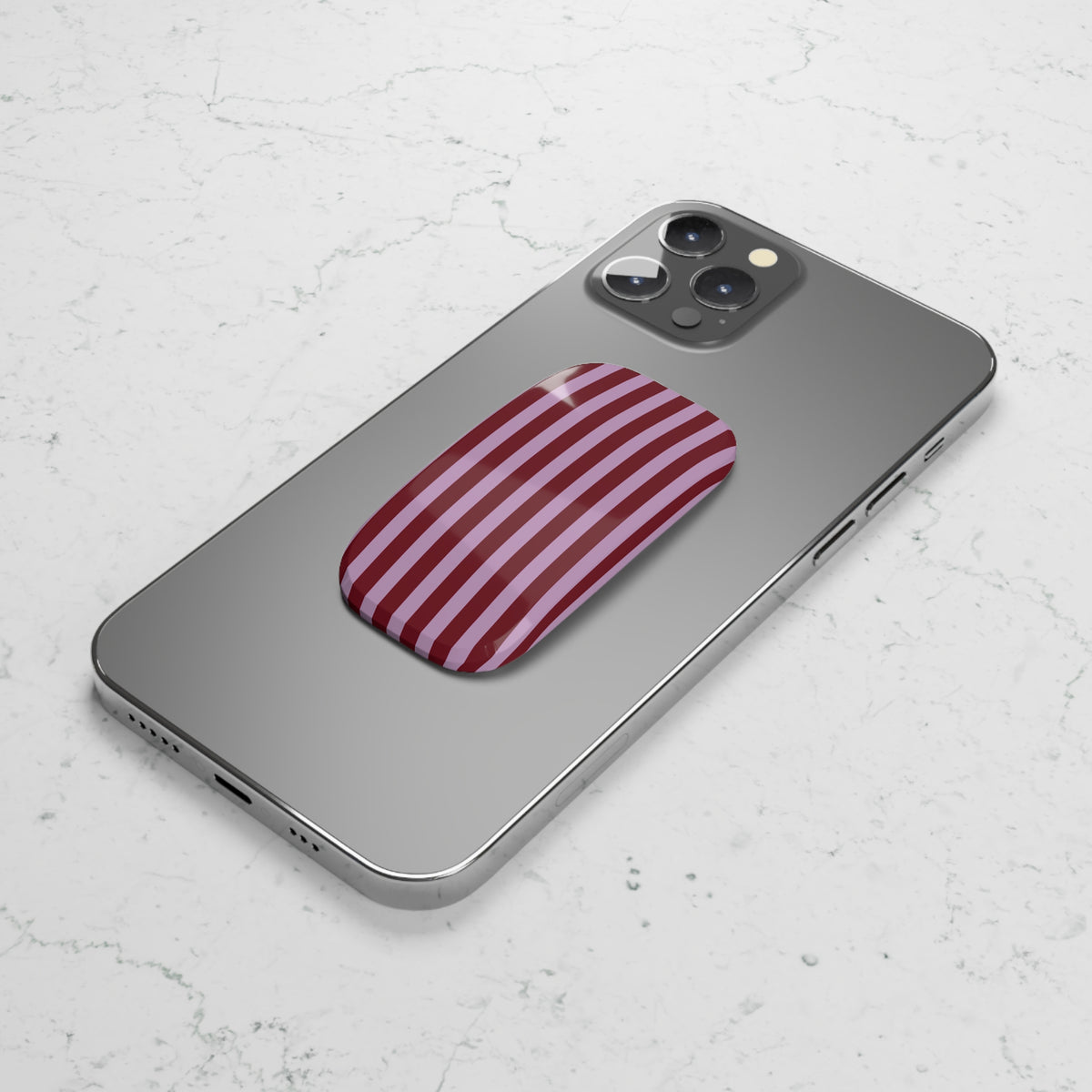 Burgundy pink striped phone grip used as a kickstand
