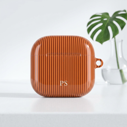 Burnt orange vertical stripe print with cream initials for an AirPod case