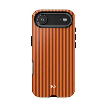 Burnt orange pinstripe print with cream initials on a dual layer phone case