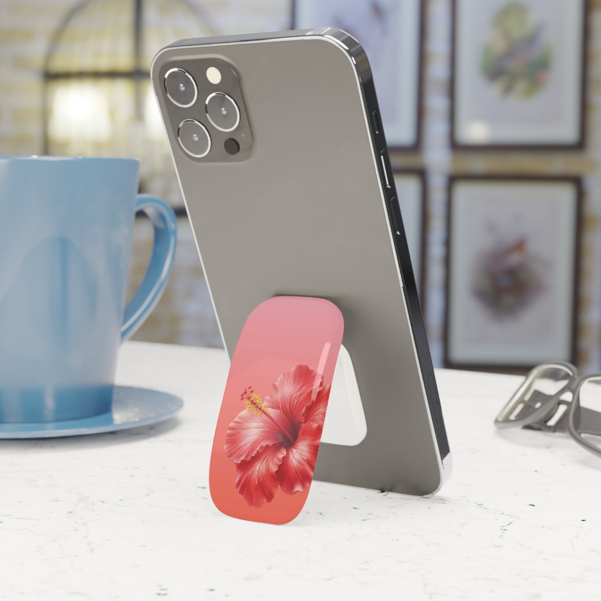 Hibiscus phone grip in coral and pink on the back of a phone