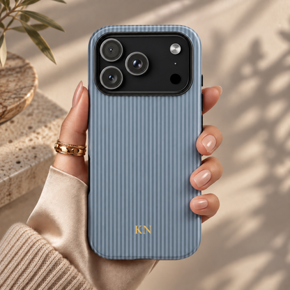 Dusty blue striped tough phone case held in hand with gold initials