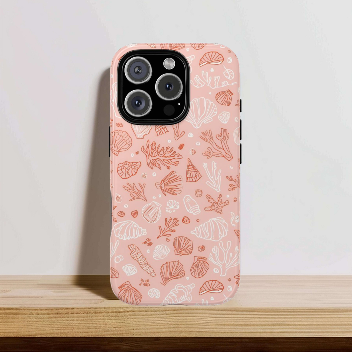 Close-up of the coral and shell print on the pink seashell phone case
