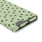 Sage green polka dot phone case with card holder, angled view